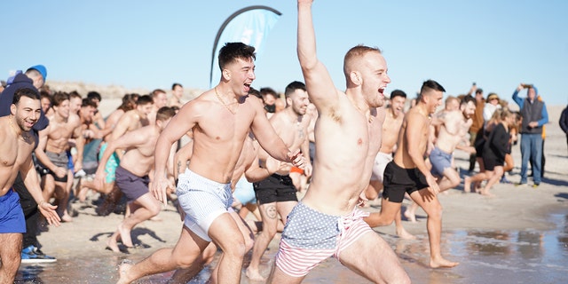 A group of Long Islanders run into the ocean at Field 5 of Long Island's Robert Moses beach on New Year's Day 2023.