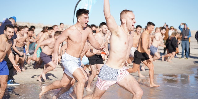 A group of Long Islanders run into the ocean at Field 5 of Long Island's Robert Moses beach on New Year's Day 2023.