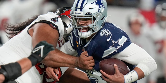 Le plaqueur défensif des Buccaneers de Tampa Bay Vita Vea limoge le quart-arrière des Cowboys de Dallas Dak Prescott (4) au cours de la première moitié d'un match de football avec joker de la NFL, le lundi 16 janvier 2023, à Tampa , en Florida.