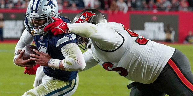 Tampa Bay Buccaneers defensive end Akiem Hicks (96) tries to tackle Dallas Cowboys quarterback Dak Prescott (4) during the first half of an NFL wild-card football game, Monday, Jan. 16, 2023, in Tampa, Fla.