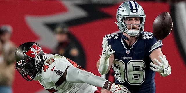 Dallas Cowboys tight end Dalton Schultz (86) vies for the catch against Tampa Bay Buccaneers linebacker Devin White (45) during the second half of an NFL wild-card football game, Monday, Jan. 16, 2023, in Tampa, Fla. 