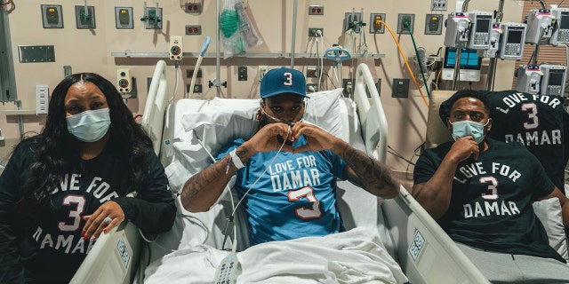 Damar Hamlin, centro, mirando a los Buffalo Bills desde su cama de hospital.