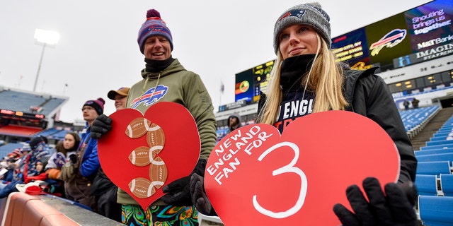 Aficionados de los New England Patriots sostienen carteles en apoyo del profundo de los Buffalo Bills, Damar Hamlin, el domingo 8 de enero de 2023 en Orchard Park, Nueva York.
