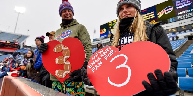 Aficionados de los New England Patriots sostienen carteles en apoyo del profundo de los Buffalo Bills, Damar Hamlin, el domingo 8 de enero de 2023 en Orchard Park, Nueva York.