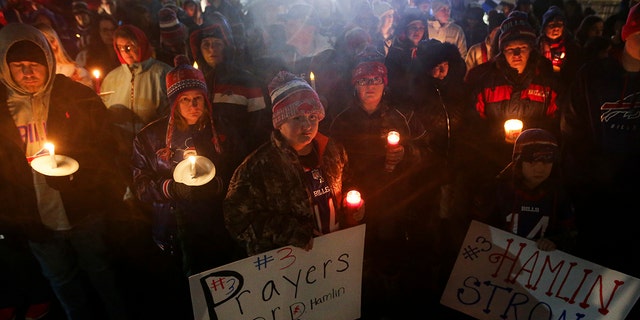 Buffalo Bills fans and community members gather for a candlelight vigil for Bills safety Damar Hamlin on Tuesday in Orchard Park, New York. Hamlin collapsed Monday while going into cardiac arrest after making what appeared to be a routine tackle during the team's NFL game against the Cincinnati Bengals in Cincinnati. Hamlin was sedated and in critical condition Tuesday.