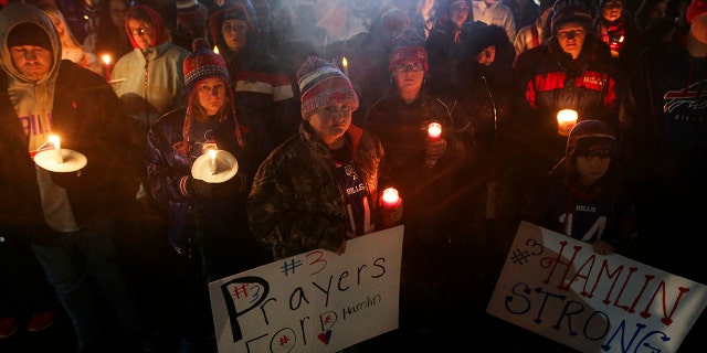 Buffalo Bills fans and community members gather for a candlelight vigil for Bills safety Damar Hamlin on Tuesday in Orchard Park, New York. Hamlin collapsed Monday while going into cardiac arrest after making what appeared to be a routine tackle during the team's NFL game against the Cincinnati Bengals in Cincinnati. Hamlin was sedated and in critical condition Tuesday.