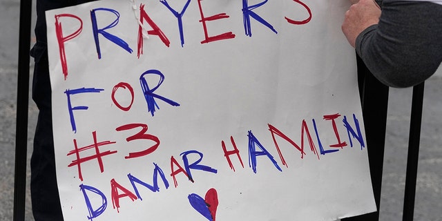 A poster is attached to a fence outside of University of Cincinnati Medical Center in Cincinnati on Tuesday. Buffalo Bills safety Damar Hamlin was taken to the hospital after collapsing on the field during an NFL game against the Cincinnati Bengals on Monday night.
