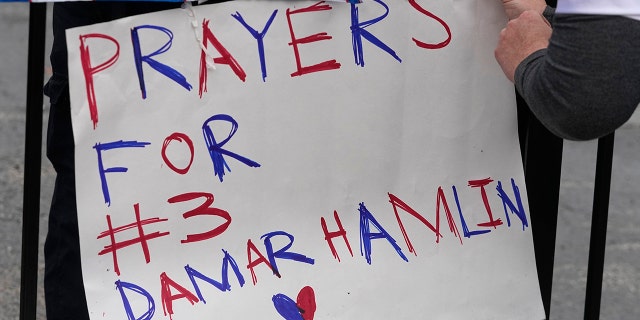 A poster is attached to a fence outside of University of Cincinnati Medical Center, Tuesday, Jan. 3, 2023, in Cincinnati. Buffalo Bills' Damar Hamlin was taken to the hospital after collapsing on the field during an NFL football game against the Cincinnati Bengals on Monday night.