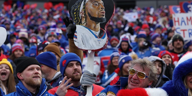 Buffalo Bills fans hold a photo of Damar Hamlin (3) during the game against the New England Patriots at Highmark Stadium.  Buffalo.