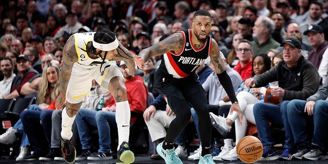 Damian Lillard #0 of the Portland Trail Blazers dribbles the ball while defended by Jordan Clarkson #00 (L) of the Utah Jazz during the second half at Moda Center on January 25, 2023, in Portland, Oregon.