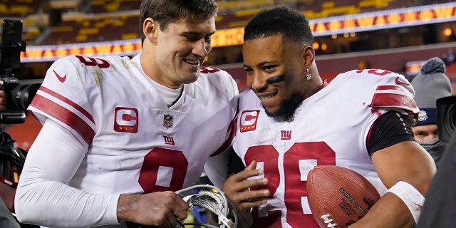 Daniel Jones y Saquon Barkley de los New York Giants salen del campo después de una victoria de 20-12 sobre los Washington Commanders, el 18 de diciembre de 2022, en Landover, Maryland.