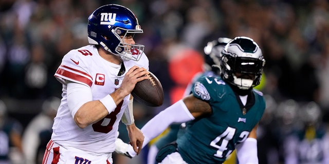 New York Giants quarterback Daniel Jones, left, runs with the ball as Philadelphia Eagles linebacker Kyzir White chases him during the first half of an NFL divisional round football game , on Saturday, January 21, 2023, in Philadelphia. 
