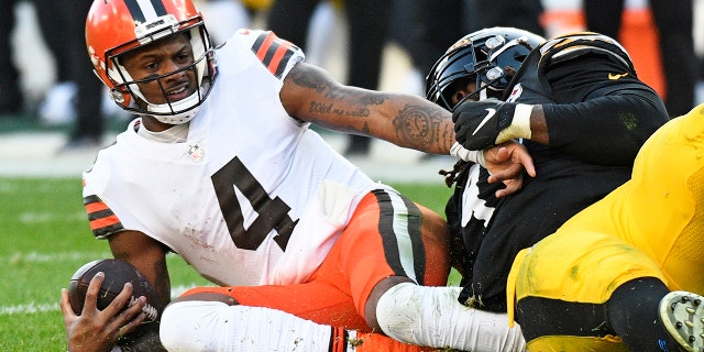 Cleveland Browns oyun kurucusu Deshaun Watson, 8 Ocak 2023 Pazar günü Pittsburgh'da oynanan bir NFL futbol maçının ikinci yarısında Pittsburgh Steelers'ın defans oyuncusu Larry Ogunjobi tarafından kovuldu.
