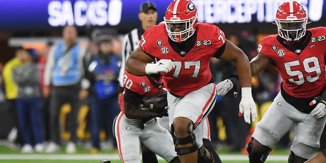 Georgia Bulldogs offensive linemen Devin Willock (77) runs blocks during the CFP National Championship game against the TCU Horned Frogs on January 9, 2023 at SoFi Stadium in Inglewood, California.