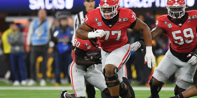 Georgia Bulldogs Offensive Linemen Devin Willock, #77, run blocks during the CFP National Championship game between the TCU Horned Frogs and the Georgia Bulldogs on Jan. 9, 2023, at SoFi Stadium in Inglewood, California.