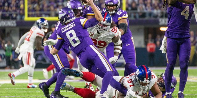 New York Giants defensive tackle Dexter Lawrence (97) trips up Minnesota Vikings quarterback Kirk Cousins (8) during the NFL game between the New York Giants and Minnesota Vikings on January 15, 2023, at U.S. Bank Stadium in Minneapolis.
