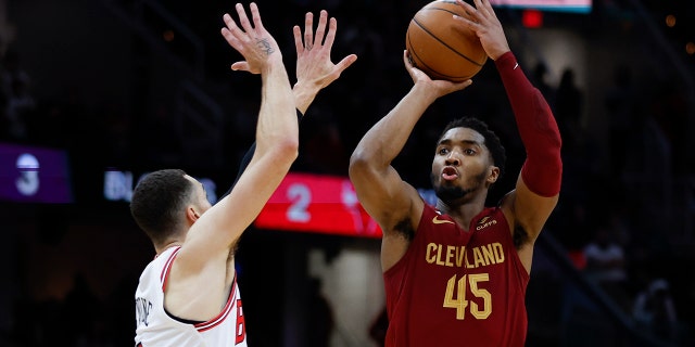 El escolta de los Cavaliers de Cleveland, Donovan Mitchell (45), dispara contra el escolta de los Bulls de Chicago, Zach LaVine (8), durante la segunda mitad de un partido de baloncesto de la NBA, el lunes 2 de enero de 2023 en Cleveland.