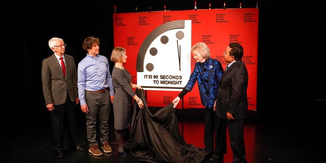 Siegfried Hecker (from left), Daniel Holz, Sharon Squassoni, Mary Robinson and Elbegdorj Tsakhia of the Bulletin of the Atomic Scientists remove a cloth covering the doomsday clock before a virtual news conference at the National Press Club in Washington Tuesday, January 24, 2023