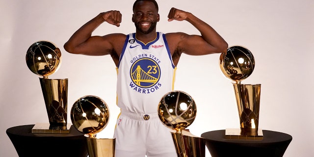 Golden State Warriors forward Draymond Green poses with the Larry O'Brien championship trophies during Media Day at the Chase Center in San Francisco on September 25, 2022.