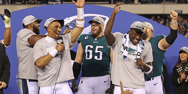 Jan 29, 2023; Philadelphia, Pennsylvania, USA;  Philadelphia Eagles quarterback Jalen Hurts (1) celebrates with offensive tackle Lane Johnson (65) and wide receiver A.J. Brown (11) during the NFC Championship trophy presentation after win against the San Francisco 49ers in the NFC Championship game at Lincoln Financial Field.