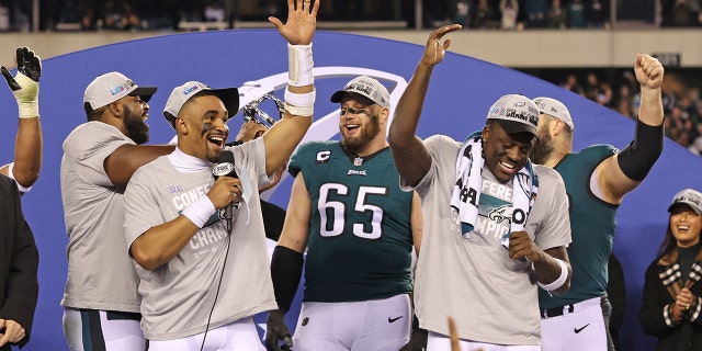 Jan 29, 2023; Philadelphia, Pennsylvania, USA;  Philadelphia Eagles quarterback Jalen Hurts (1) celebrates with offensive tackle Lane Johnson (65) and wide receiver A.J. Brown (11) during the NFC Championship trophy presentation after win against the San Francisco 49ers in the NFC Championship game at Lincoln Financial Field.