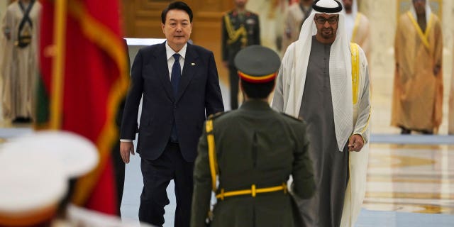 South Korean President Yoon Suk Yeol, center left, and Emirati leader Sheikh Mohammed bin Zayed Al Nahyan walk past an honor guard at Qasar Al Watan in Abu Dhabi, United Arab Emirates, Sunday, Jan. 15, 2023. Yoon received an honor guard welcome Sunday on a trip to the United Arab Emirates, where Seoul hopes to expand its military sales while finishing its construction of the Arabian Peninsula's first nuclear power plant. (AP Photo/Jon Gambrell)