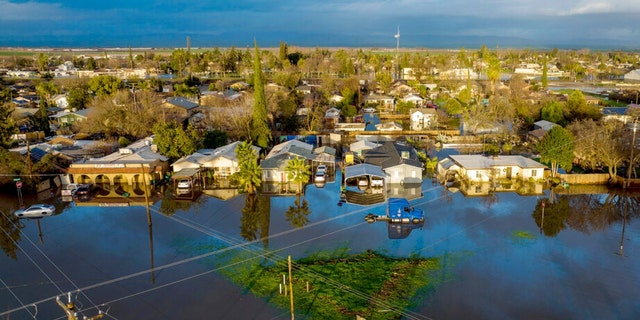 Following days of rain, floodwaters surround homes and vehicles in the Planada community of Merced County, Calif., on Jan. 10, 2023. 