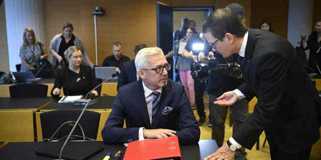 Editor-in-chief of Helsingin Sanomat Kaius Niemi, right, speaks with his lawyer Kai Kotiranta, left, ahead of the hearing for the Helsingin Sanomat journalists who are accused of disclosing state secrets in Helsinki, on Aug. 25, 2022. 