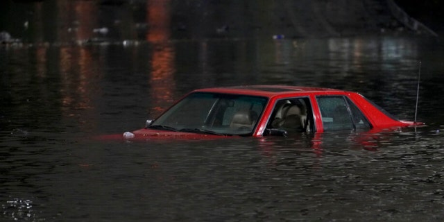 An empty vehicle is surrounded by floodwaters on a road in Oakland, Calif., Wednesday, Jan. 4, 2023. 