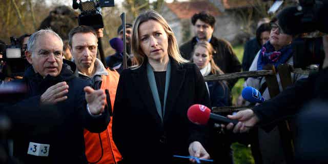 French Secretary of State for Ecology Berangere Couillard holds a tool designed for safety during hunting, in Dry, France, on Jan. 9, 2023. New plans to tighten hunting safety regulations in the country where unveiled on Monday.