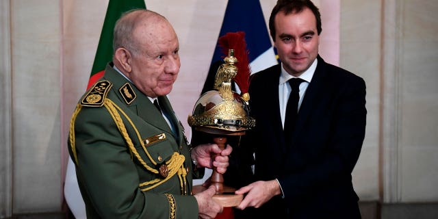 Algerian Army chief, Gen. Said Chanegriha, left, gets a present given by French Defense Minister Sebastien Lecornu, on Jan. 24, 2023 in Paris.