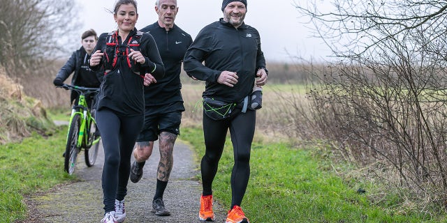 McKee (at right, wearing hat and smiling) ran the same 26.2-mile route virtually every day for a year while pursuing his challenge.