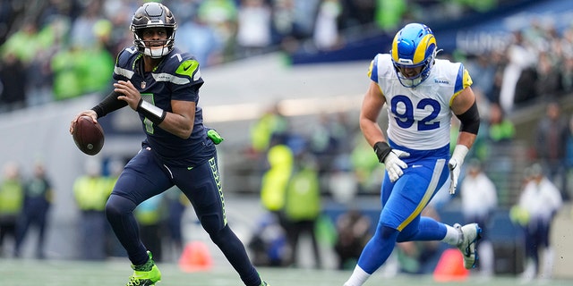 Seattle Seahawks quarterback Geno Smith (7) runs past Los Angeles Rams defensive tackle Jonah Williams (92) during the first half of a game Jan. 8, 2023, in Seattle. 