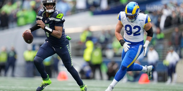 Seattle Seahawks quarterback Geno Smith (7) gets past Los Angeles Rams defensive tackle Jonah Williams (92) during the first half of a game on January 8, 2023 in Seattle. 