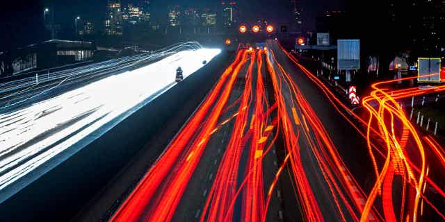 A long exposure photo shows cars and trucks driving on a highway near Frankfurt, Germany, on Jan. 23, 2023. A prominent environmental group in Germany is suing the country's government over the failure to meet its climate targets.