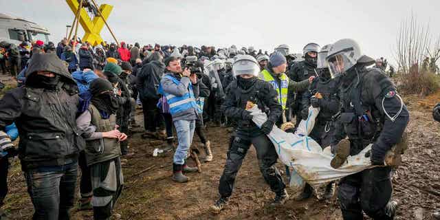 Police carry a demonstrator to clear a road at Luetzerath, Germany, on Jan. 10, 2023.