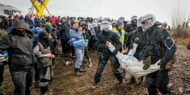 Police carry a demonstrator to clear a road at Luetzerath, Germany, on Jan. 10, 2023.