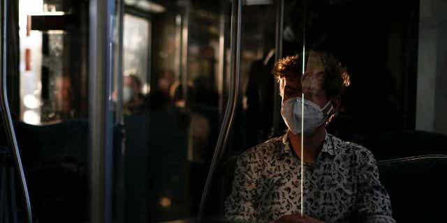 A man wearing a face mask to protect against coronavirus travels in Berlin, Germany, on March 22, 2022. A German doctor has been sentenced to nearly three years in prison for illegally issuing people exemptions from wearing masks during the coronavirus pandemic.