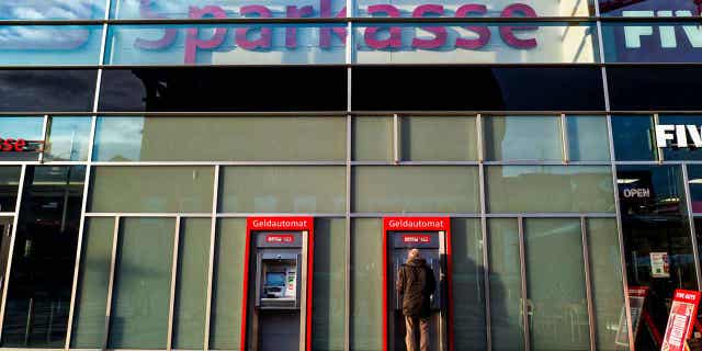 A man uses an ATM at a bank in Berlin, Germany, on Dec. 26, 2022. Germany recorded its highest annual inflation rate in more than 70 years in 2022.