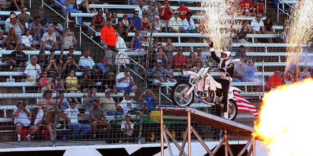 Motorcycle daredevil Robbie Knievel pumps up the crowd prior to jumping a line of police cars, ambulances and a fire truck spanning 200 feet in his "Above the Law" jump before the IZOD IndyCar Series Firestone 550k at Texas Motor Speedway June 5, 2010, in Fort Worth, Texas.  