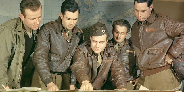 A B-17 crew from the United States Army Air Force's Eighth Air Force, 385th Bomb Group, plot a target on a map prior to a mission, England, circa 1943. At center is First Lieutenant Louis A. Dentoni Jr. (died 1944). Second from left is Lieutenant Colonel Vincent W. Masters. 
