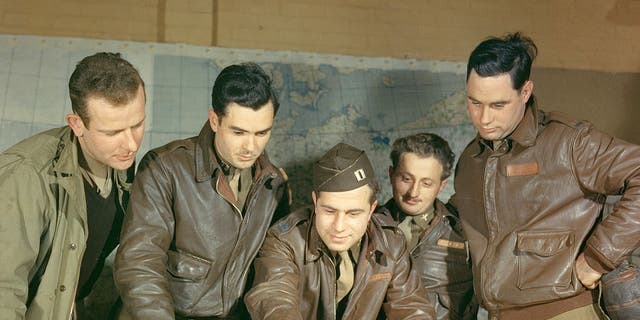 A B-17 crew from the United States Army Air Force's Eighth Air Force, 385th Bomb Group, plot a target on a map prior to a mission, England, circa 1943. At center is First Lieutenant Louis A. Dentoni Jr. (died 1944). Second from left is Lieutenant Colonel Vincent W. Masters. 