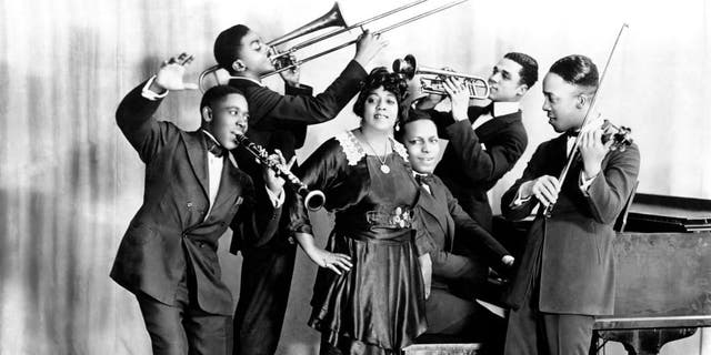 Jazz and blues singer Mamie Smith and Her Jazz Hounds (including Willie "The Lion" Smith on piano) pose for a portrait circa 1920 in New York City. Smith performed "Crazy Blues," the first blues hit record, with Her Jazz Hounds in 1920. 