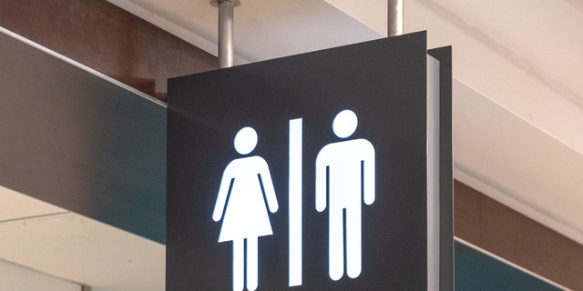 Public washroom or bathroom sign hanging from the ceiling. 