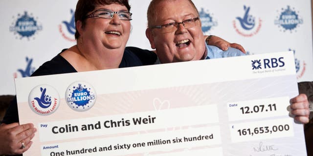 Colin Weir and his wife Christine pose during a photocall in Falkirk, Scotland, after winning a record EuroMillions jackpot on July 15, 2011.