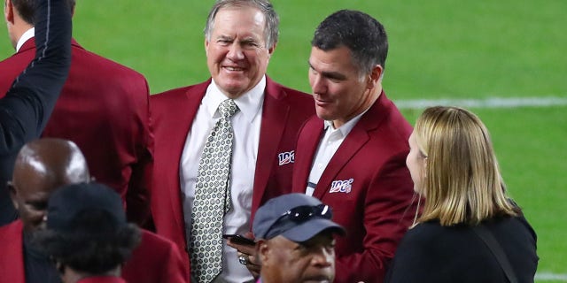 Bill Belichick and Adam Vinatieri talk on the field during the 100-year team celebration prior to Super Bowl LIV Feb. 2, 2020, at Hard Rock Stadium in Miami Gardens, Fla.