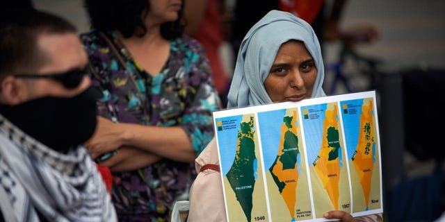 Seorang wanita memegang peta Palestina dari tahun 1946 hingga 2020. Pendukung Palestina mengadakan pertemuan di Toulouse menentang rencana aneksasi sebagian Tepi Barat dan aneksasi total Lembah Yordan oleh pemerintah Netanyahu pada 1 Juli 2020. 