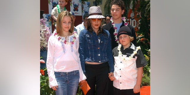 Lisa Marie Presley and her children Benjamin Keough (R),  Riley Keough (L), and her half-brother Navarone Garibaldi (back) attend the premiere of "Lilo and Stitch" at the El Capitan theatre in Hollywood on June 16, 2002. 