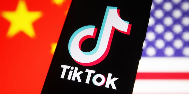UKRAINE - 2020/10/08: Dans cette illustration photo, un logo de service de réseau social de partage de vidéos TikTok chinois affiché sur un smartphone avec des drapeaux des États-Unis et de la Chine en arrière-plan.  (Photo Illustration par Pavlo Gonchar/SOPA Images/LightRocket via Getty Images)