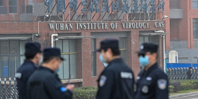 Security personnel stand guard outside the Wuhan Institute of Virology in Wuhan as members of the World Health Organization (WHO) team investigating the origins of the COVID-19 coronavirus make a visit to the institute in Wuhan in China's central Hubei province on February 3, 2021.